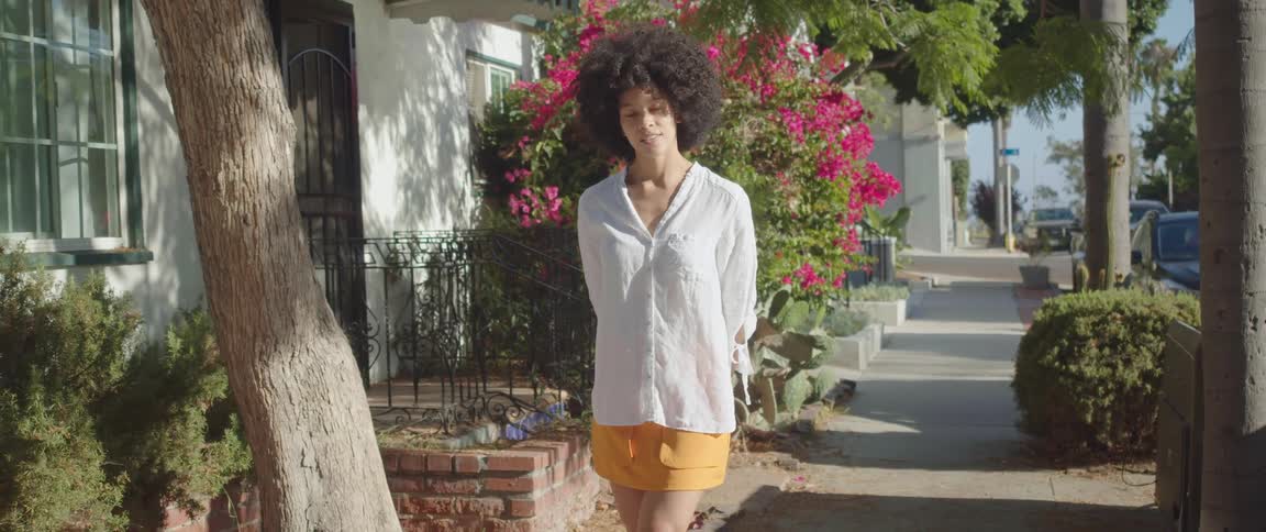 A female model poses and walks on a sidewalk