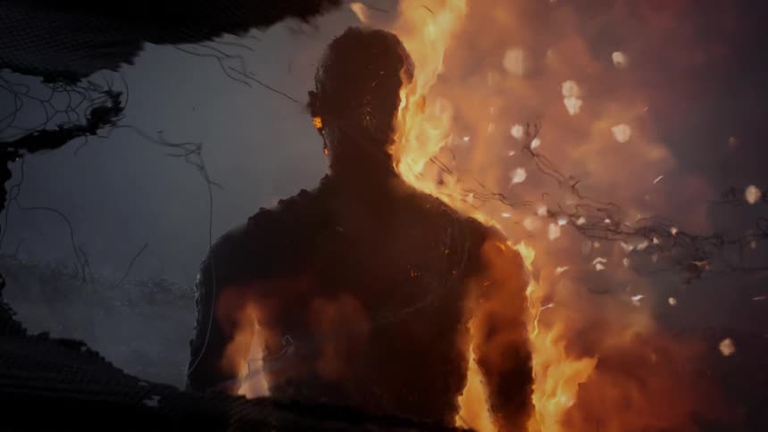 A person standing engulfed in flames with pieces of fabric blowing in the wind