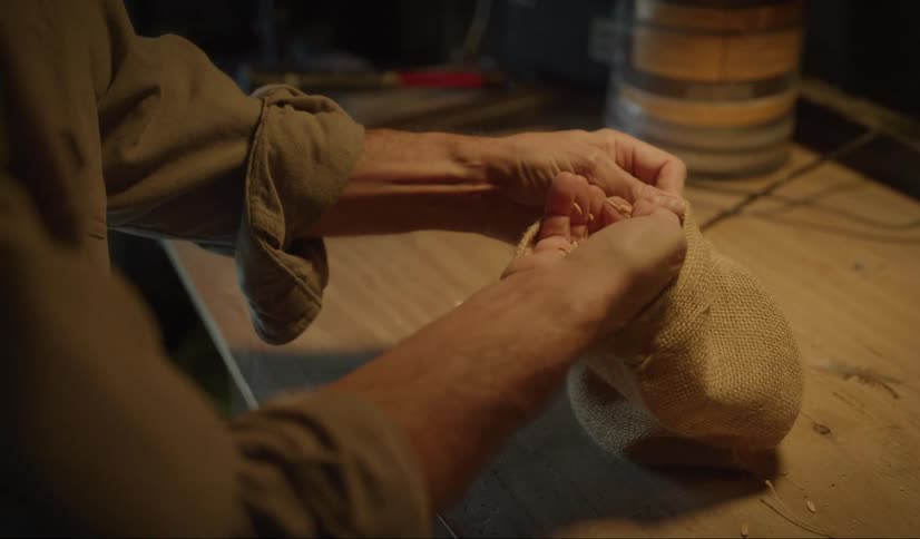 A person reaching into a bag and grabbing grain