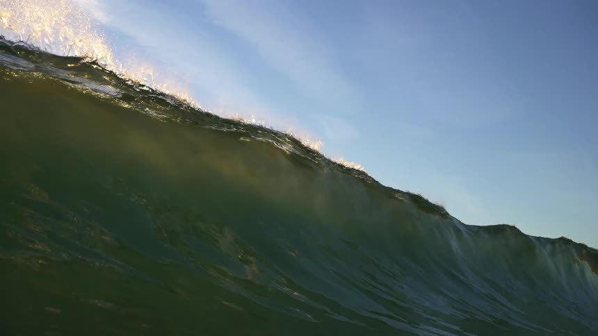 Huge wave rolls in and over head on a cloudy day