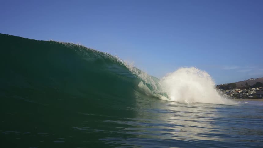 Big wave rolls in splashing on a clear day