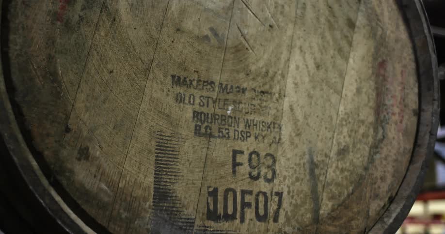 A stamp on a wooden barrel of bourbon whiskey in a warehouse