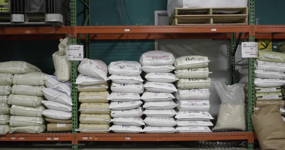 Empty wooden pallets sit on shelf over stacked sacks