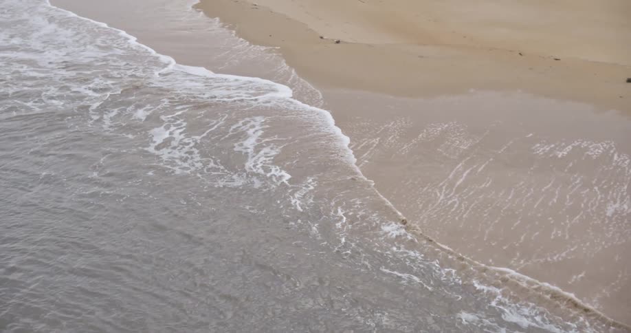 The water slowly moves over the sand