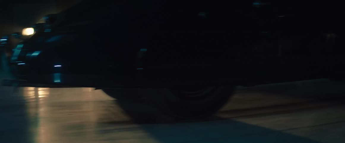 Car speeds along road at night
