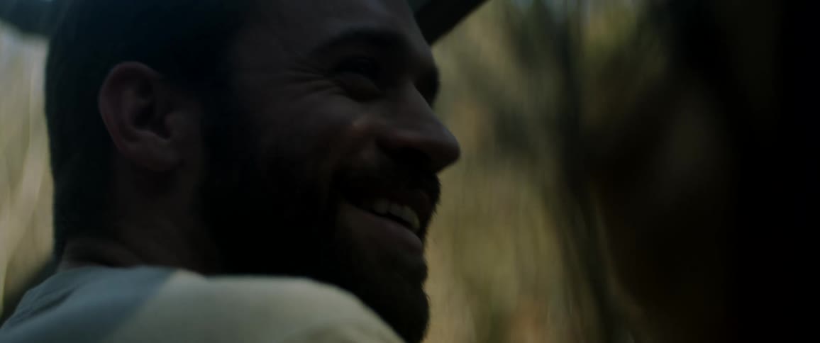 A man sits next to another person laughing and talking