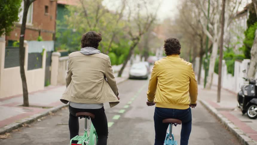 Two men biking down a road