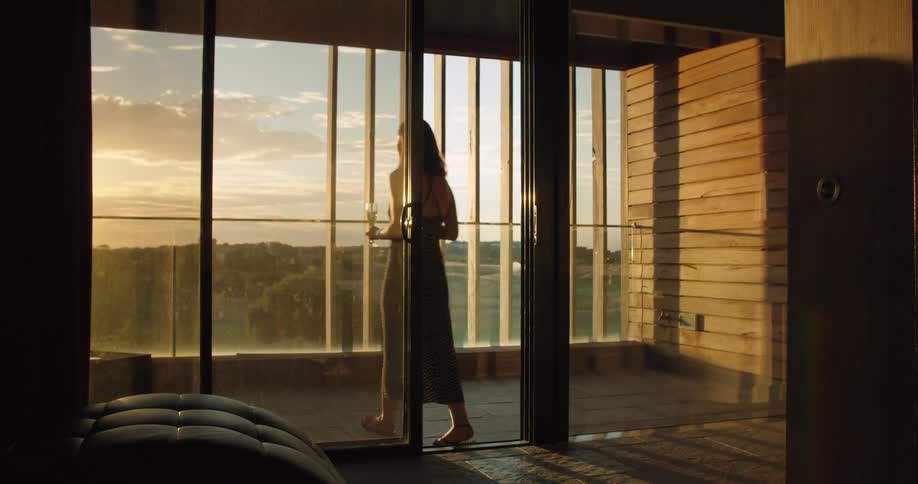 A woman carries some wine onto the terrace