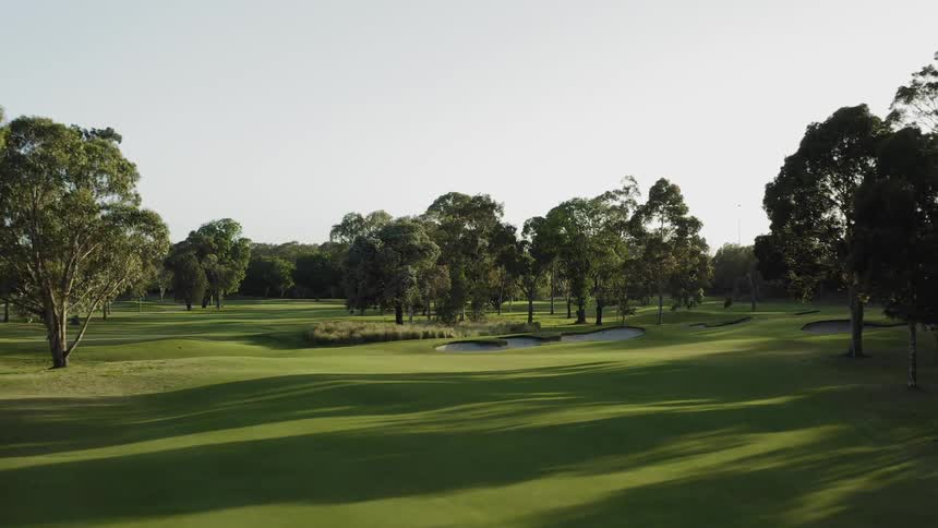 Aerial view of the green grass of a golf course in the morning