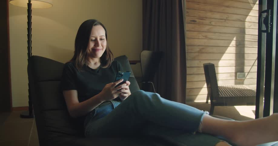 A woman is sitting down using her phone