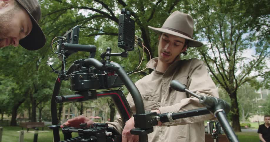 Two men work on a piece of equipment standing outdoors