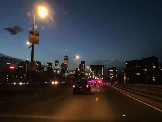 Vehicles drive towards the bridge following an ambulance