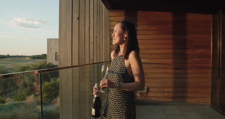 A woman walking to her patio with a drink