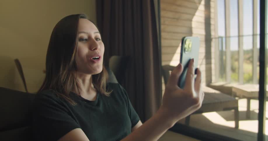 A woman is talking on a phone while sitting in a room