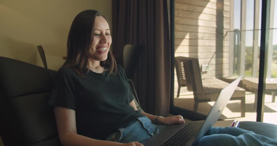 A woman talks on the laptop in her home