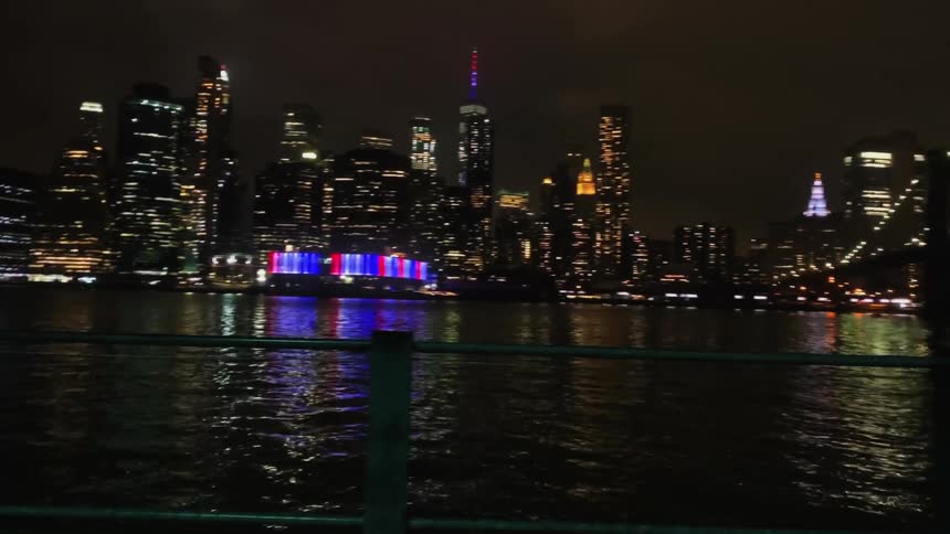 City with lights illuminated at night against a body of water