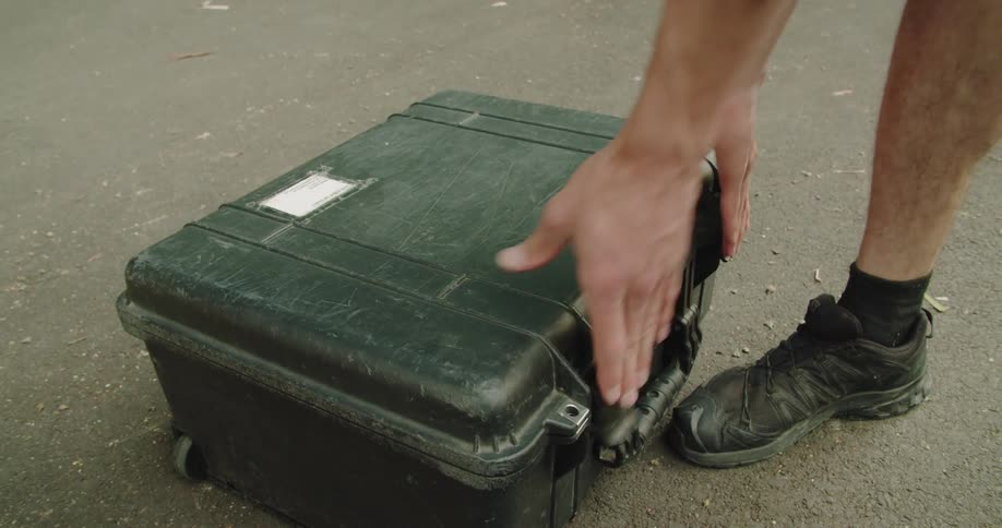 Photographer storing camera equipment and lenses on a case