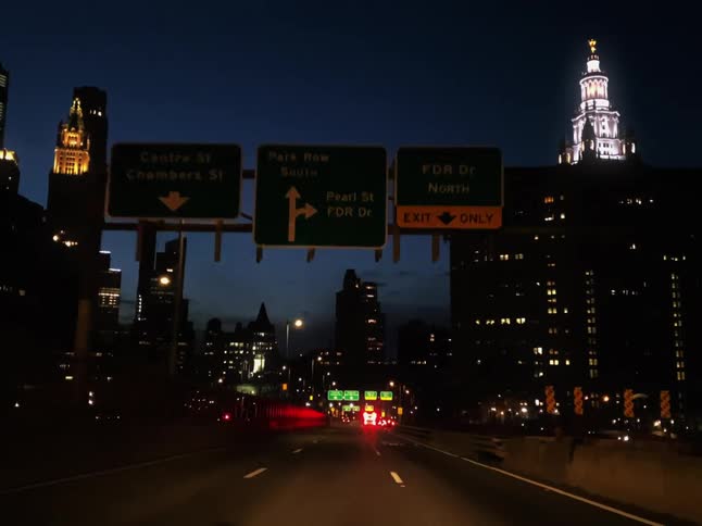 Car driving on the highway through the skycscrapers on the citys downtown at evening
