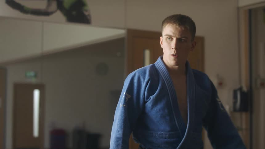A man walking into a room with a robe on