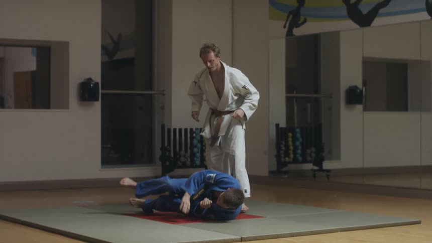 A man flips another man over as they fight in a martial arts competition