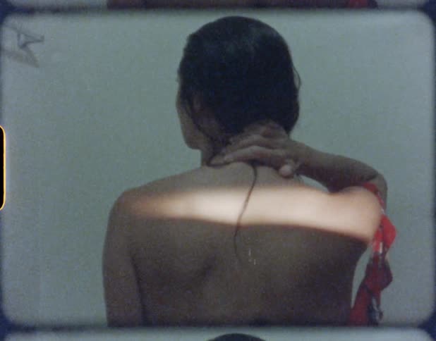 A woman in a room rubbing her neck