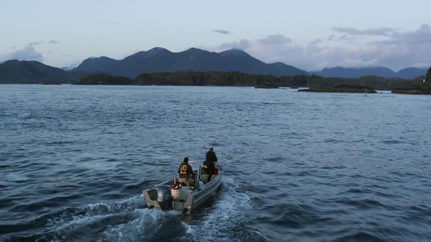 A man points as him and another man boat towards the shore