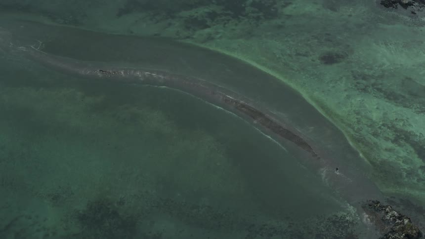 Aerial view of a narrow sand bank on the clear waters of a lake