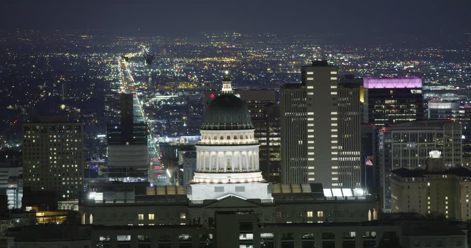 The brightly illuminated domed tower of a government building in a metropolis at night