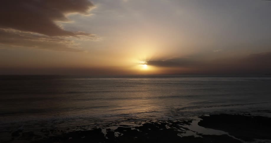 An aerial view of the sun setting over the water