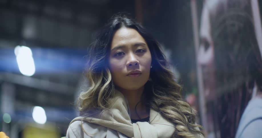 Young woman standing on a hallway at night looking at the camera
