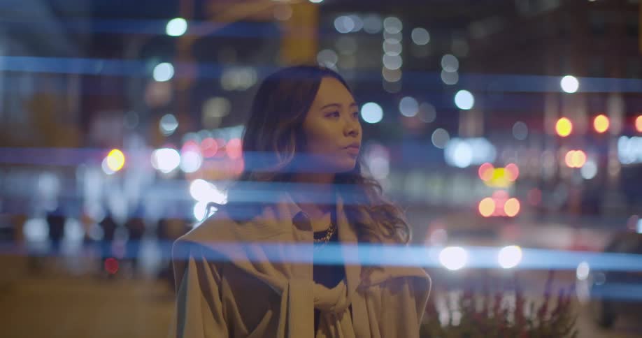 Young woman walking on the citys downtown streets at night