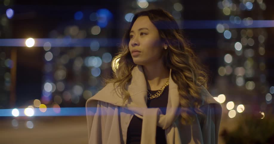 Young woman standing on the street on the citys downtown at night