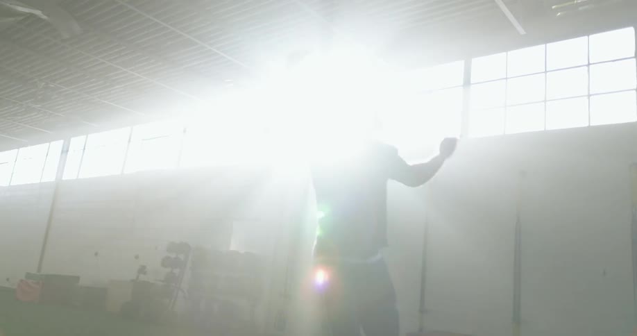 A man swinging from gym equipment and doing a flip in the air
