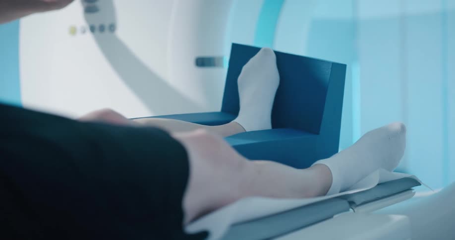A man lies with his left leg slightly elevated on an mri machine
