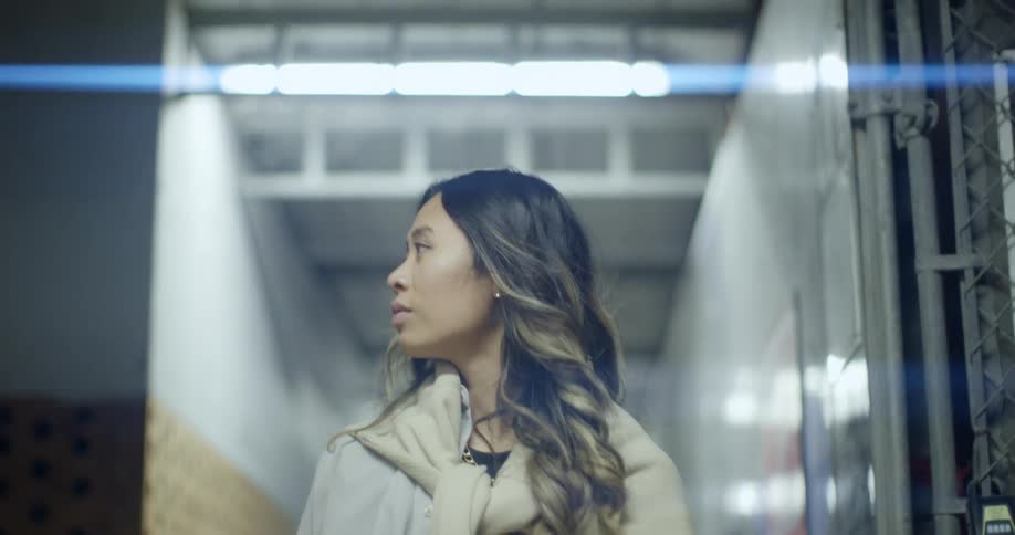 A young woman looks around as she walks through a building
