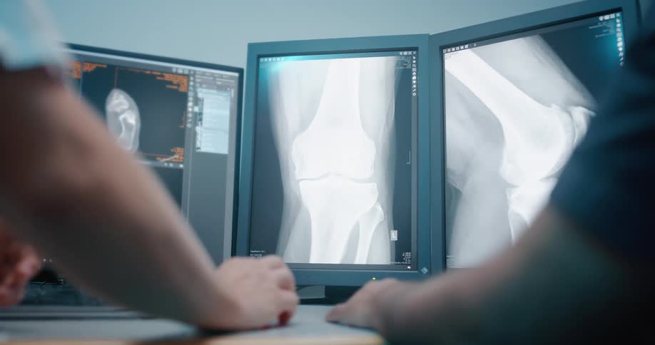 Two people review x ray images on a monitor