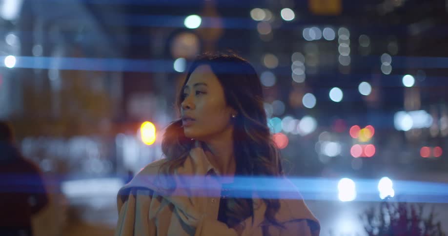 Young woman walking on the streets of the citys downtown at night