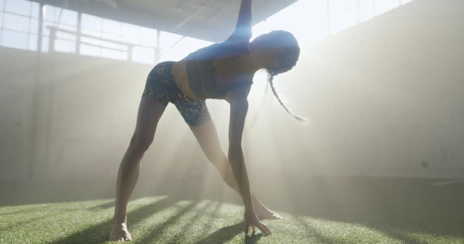 A young woman stretches as she exercises