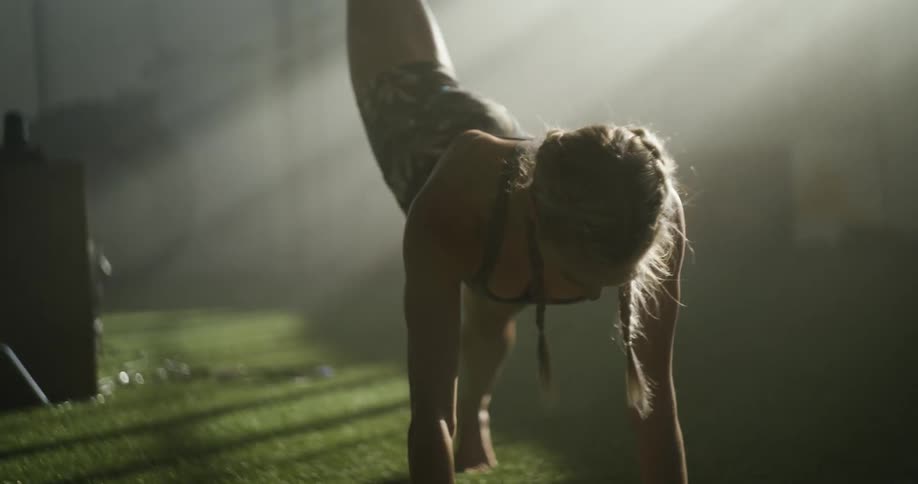 A woman stretching and exercising in a sunny fitness room