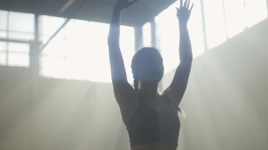 A woman is exercising indoors during the day