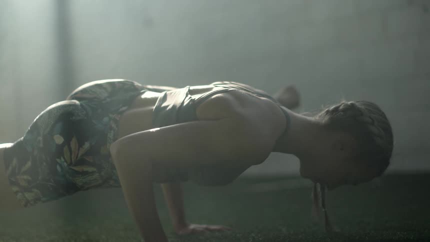 Blonde woman with braids exercises in sunlight