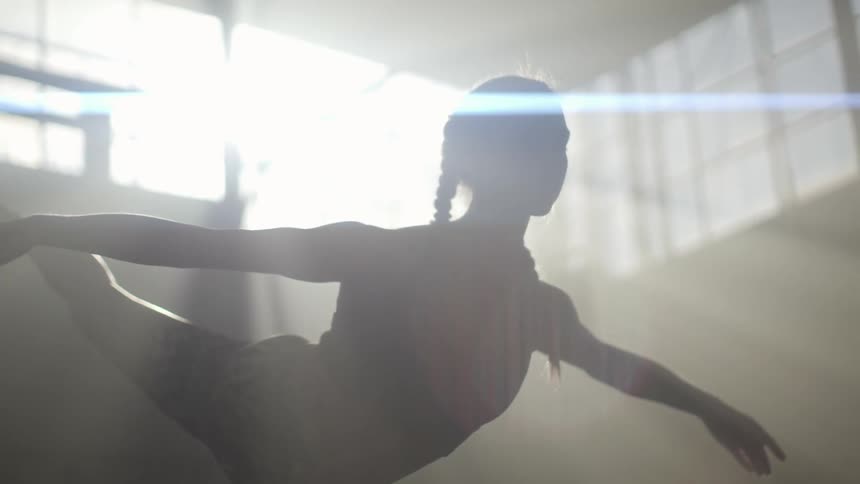 A woman gracefully bends forward while raising her leg in the air in a stretch yoga pose