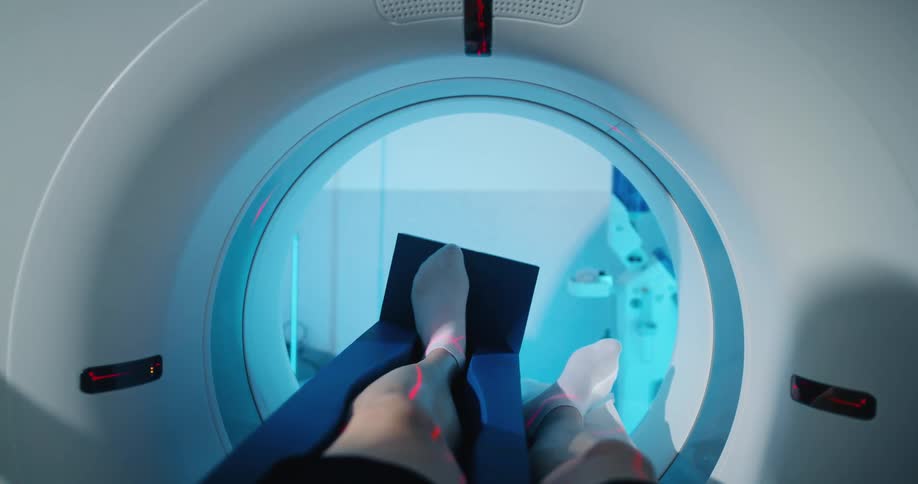 The outstretched legs of a man go through the imaging machine first