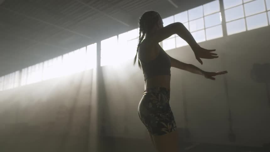A woman is stretching indoors during the day
