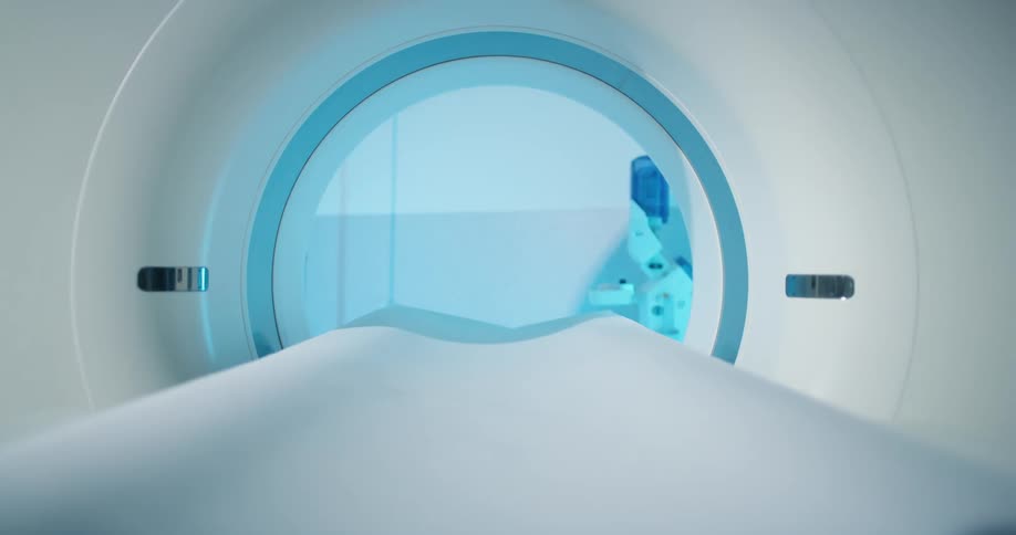 A person pushing a button on a mri machine