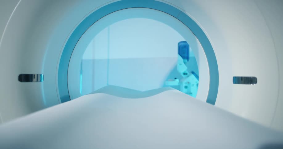The bed of a magnetic resonance imaging machine entering the tube in a hospital
