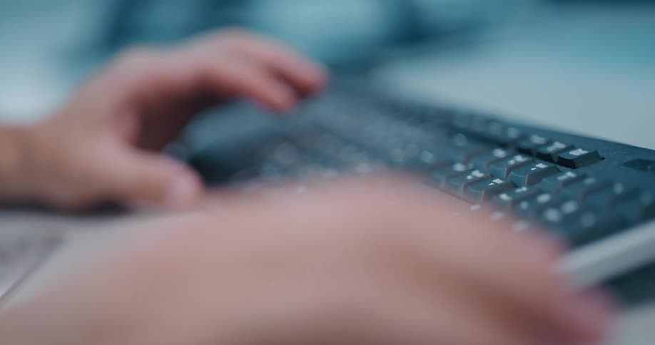 Hands tap on a keyboard and control a mouse