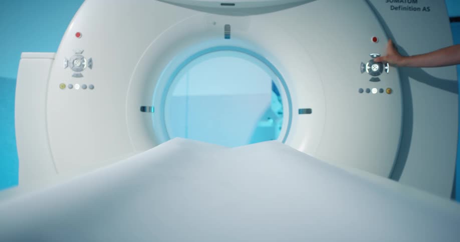 A technician presses a button on a mri machine