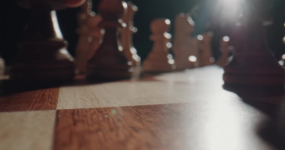 A person moving a piece on a chessboard