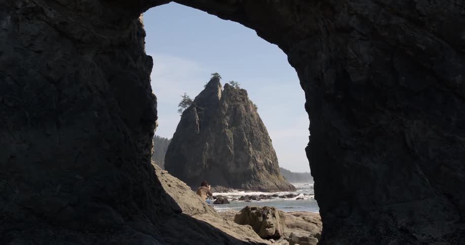 A hole in rocks by the shore leads to water